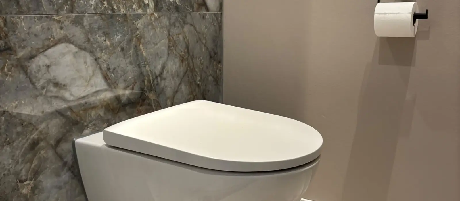 Hangtoilet tegen een marmeren wand