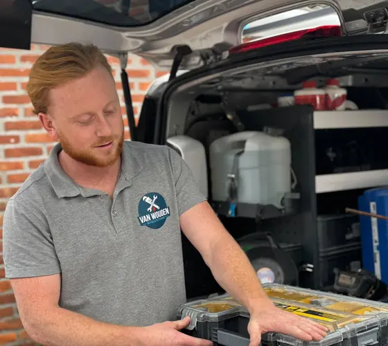Phil van Wouden bij zijn servicebus in Helmond, met zijn gereedschapskoffer klaar voor de volgende klus