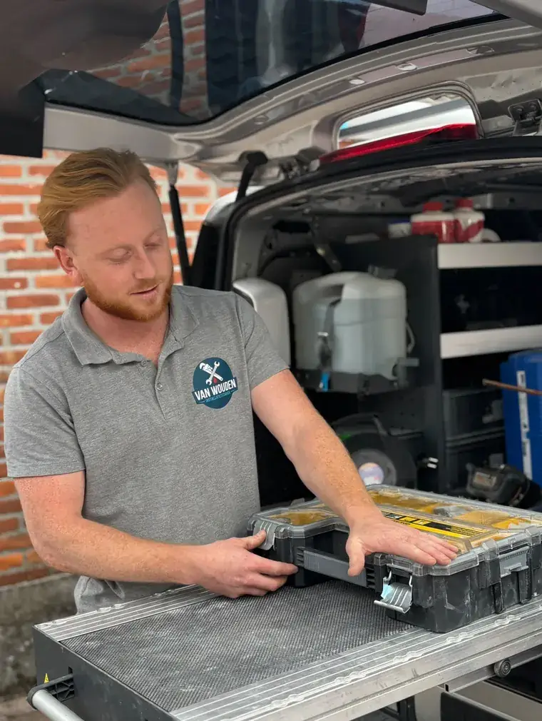 Phil van Wouden bij zijn servicebus in Helmond, met zijn gereedschapskoffer klaar voor de volgende klus